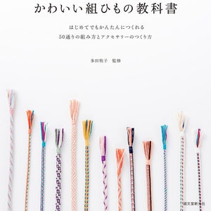 以下が含まれることがあります： 「かわいい組ひもの教科書」というタイトルの書籍の表紙。表紙には、さまざまなパターンと色でカラフルな組紐のコードが描かれており、「はじめてでもかんたんにつくれる 50通りの組み方とアクセサリーのつくり方」という日本語のテキストが書かれています。これは、「初心者でも簡単に作れます。50通りの編み方とアクセサリーの作り方」という意味です。この本は多田牧子氏によって書かれ、誠文堂新光社から出版されています。