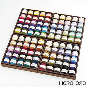 Puede incluir: Un conjunto de 120 carretes de hilo de bordar en una variedad de colores, organizados en cuatro cajas de madera. Cada caja contiene 30 carretes de hilo.