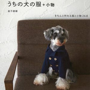 以下が含まれることがあります： 金色のボタンが付いた濃紺のコートを着た犬が、茶色の椅子に座っています。この画像は、金子俊雄著の「うちの犬の服+小物」というタイトルの日本の本からのものです。本の表紙には、犬の服のイラストが描かれています。