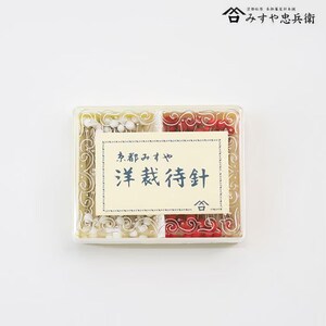 以下が含まれることがあります： 透明なプラスチックの箱に縫い針が入っています。箱は4つのセクションに分かれており、白と赤のピンが見えます。箱には装飾的なボーダーと日本語のテキストが書かれたラベルが付いています。