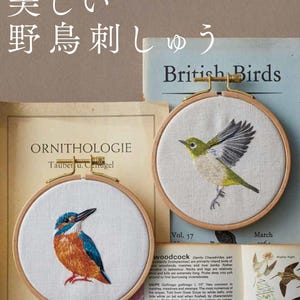 May include: Two circular wooden embroidery hoops containing fabric with stitched bird designs. One hoop features a perched kingfisher with blue and orange plumage. The other hoop displays a bird in flight with green and white feathers. Text reads CANCAN.
