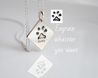 Puede incluir: Collar de plata con un colgante en forma de diamante con una huella de pata grabada y el nombre "Betty".