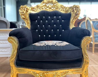 Poltrona in stile barocco retrò in velluto nero con ricami floreali e finitura dorata.