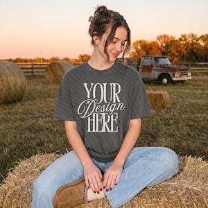May include: A charcoal gray short-sleeve t-shirt featuring the white text "YOUR DESIGN HERE" printed in a stylized serif font on the front. The garment has a crew neckline and a relaxed fit, constructed from a solid-colored cotton fabric.