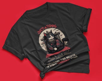 May include: Black t-shirt with a graphic of a black cat wearing a crown and sitting on a throne. The text "Dictators" is above the cat and "Creatures who believe in strict purrsonal rules" is below the cat.