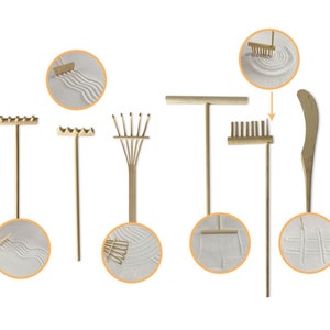 May include: A set of seven wooden tools for creating patterns in sand. The tools include a rake, a fan rake, a straight rake, a curved rake, a straight-edged tool, and a small rake. The tools are shown against a white background.