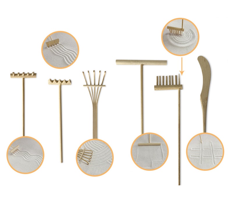 May include: A set of seven wooden tools for creating patterns in sand. The tools include a rake, a fan rake, a straight rake, a curved rake, a straight-edged tool, and a small rake. The tools are shown against a white background.