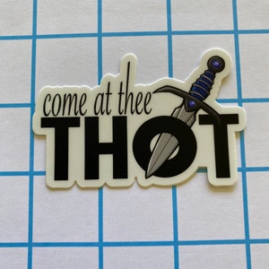 May include: A black and white sticker with the text "come at thee THOT" and a silver sword with a blue gem on the handle.
