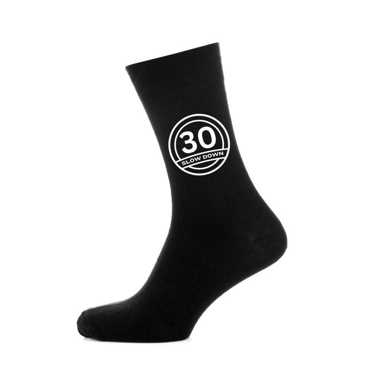 May include: Black socks with a white circle graphic that says "30 Slow Down" on them.
