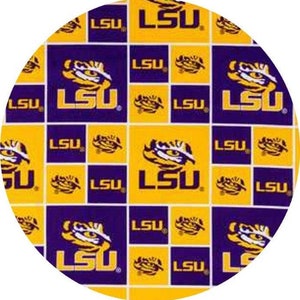 May include: Circular fabric featuring a repeating pattern of gold and purple squares. Each square displays the letters "LSU" and a tiger mascot head. The design is a bold, collegiate-themed pattern.