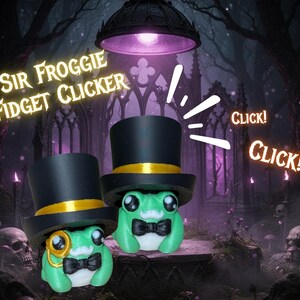 May include: Two green frog fidget clickers wearing black top hats with gold bands and black bow ties. One frog has a monocle. The image has the text "Sir Froggie Fidget Clicker" and "Click!" in a spooky forest setting.