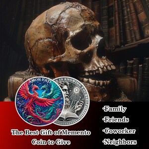 May include: Two silver coins with a skull in the background. The first coin features a colorful phoenix with the words "Amor Fati" on the top. The second coin features a man with a beard and a book with the words "Is in Knowing Yourself" on the top. The text "The Best Gift of Memento Coin to Give" is below the coins. The text "Family, Friends, Coworker, Neighbors" is on the right side of the image.