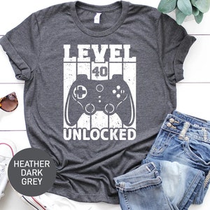 May include: Heather dark grey t-shirt with a white graphic of a video game controller and the text "LEVEL 40 UNLOCKED".