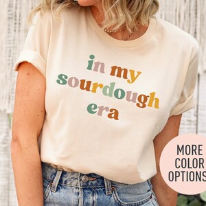 a woman wearing a t - shirt that says in my sourdough era