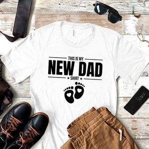 a t - shirt that says, this is my new dad shirt