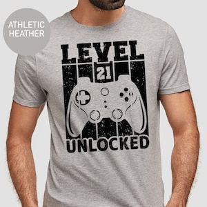 May include: A gray t-shirt with a black graphic of a video game controller and the text "LEVEL 21 UNLOCKED".