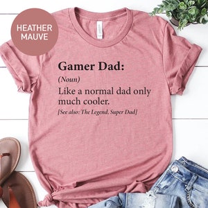 May include: Heather mauve t-shirt with the text "Gamer Dad: (Noun) Like a normal dad only much cooler. [See also: The Legend, Super Dad]"
