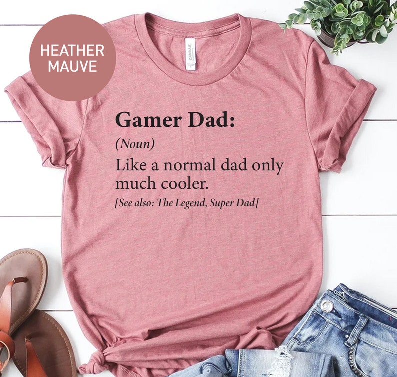 May include: Heather mauve t-shirt with the text "Gamer Dad: (Noun) Like a normal dad only much cooler. [See also: The Legend, Super Dad]"