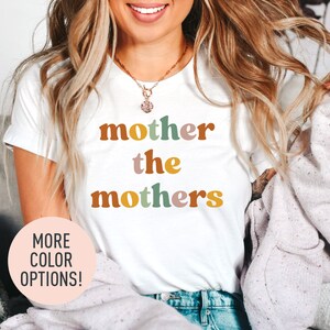 a woman wearing a t - shirt that says mother the mothers