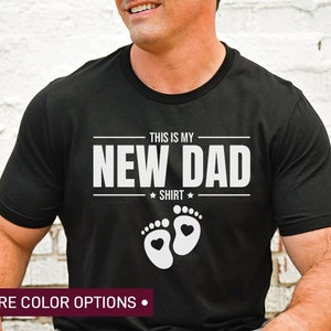 a man wearing a new dad shirt with his feet crossed