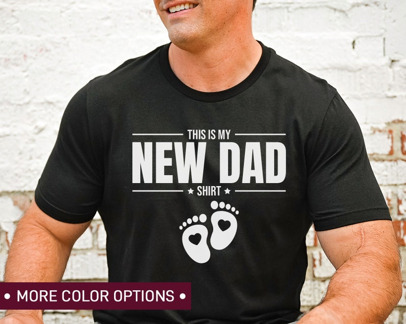 a man wearing a new dad shirt with his feet crossed