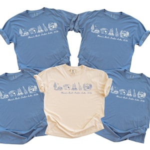 five blue t-shirts with white text and graphics, and one beige t-shirt, all of which appear to be part of a collection or merchandise.