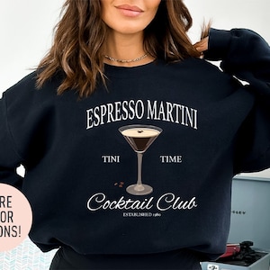 a woman wearing a black sweatshirt that says espresso martini time cocktail club