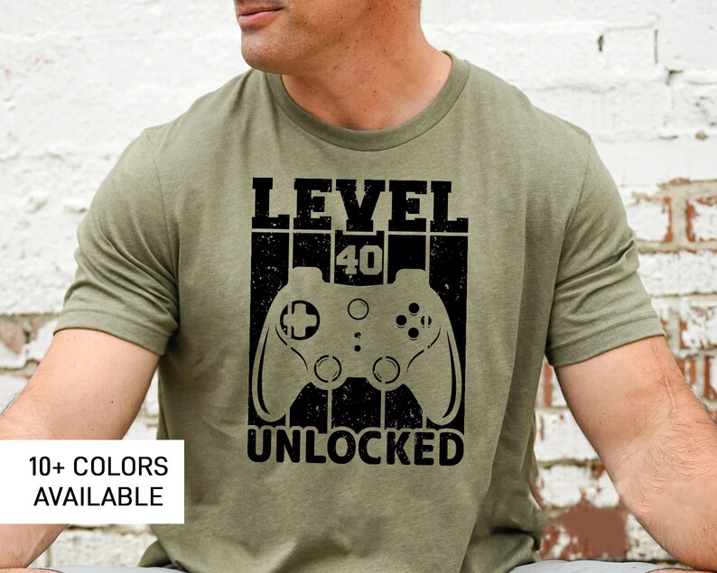 May include: A green t-shirt with a black graphic that says "Level 40 Unlocked" and features a video game controller.