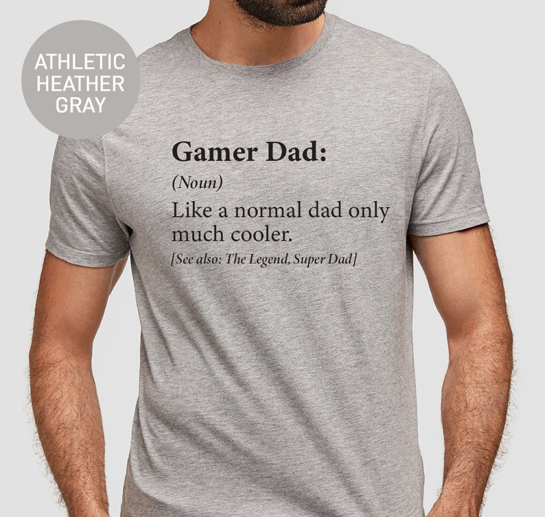 May include: A gray t-shirt with the text "Gamer Dad: (Noun) Like a normal dad only much cooler. [See also: The Legend, Super Dad]" printed on the front.