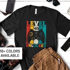 May include: Black t-shirt with a retro-style video game controller graphic and the text "Level 40 Unlocked".