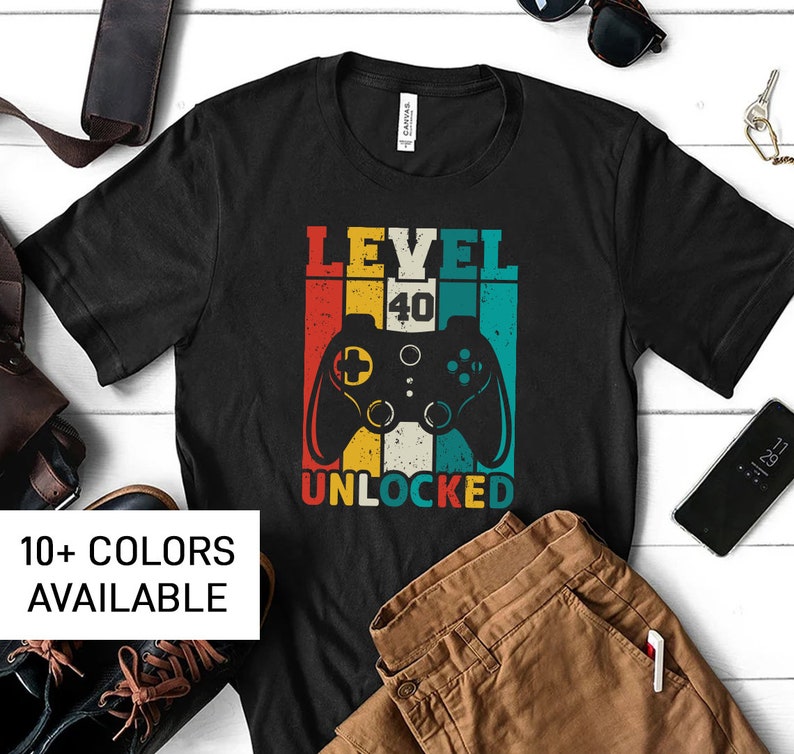 May include: Black t-shirt with a retro-style video game controller graphic and the text "Level 40 Unlocked".