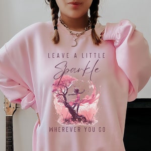 May include: Pink sweatshirt with a graphic of a girl dancing in a pink tree with the text "Leave a little Sparkle Wherever you go."