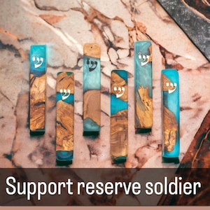 May include: Six wooden mezuzah cases with blue and white resin. Each case features a silver Hebrew inscription.