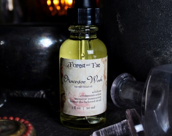 Può includere: Una piccola bottiglia di vetro ambrato con un contagocce, etichettata "of Forest and Fae Ancestor Work sacred ritual oil wisdom communication ancestor veneration honor the beloved dead 1 fl oz | 30 ml".