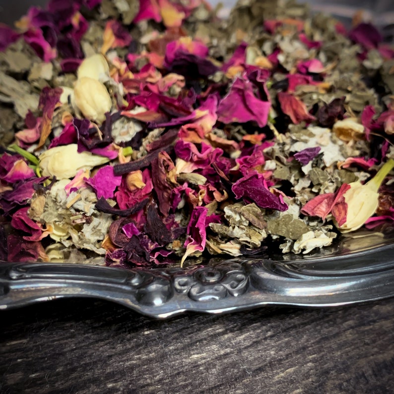 K&ouml;nnte beinhalten: Eine silberne Servierplatte gef&uuml;llt mit einer Mischung aus getrockneten Kr&auml;utern und Rosenbl&uuml;ten. Die Mischung ist hellrosa und gr&uuml;n.