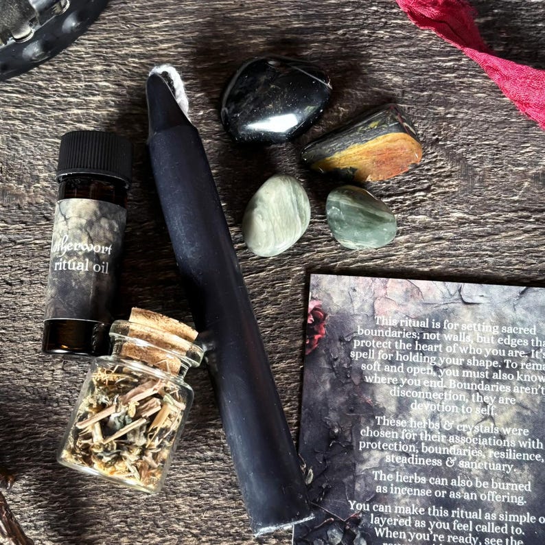 K&ouml;nnte beinhalten: Eine Sammlung von Ritualgegenst&auml;nden, darunter eine schwarze Kerze, eine kleine Flasche "Wermut-Ritual&ouml;l", ein Glas mit Kr&auml;utern und mehrere Kristalle. Eine Karte mit Text ist ebenfalls enthalten. Die Gegenst&auml;nde sind auf einer Holzoberfl&auml;che angeordnet.
