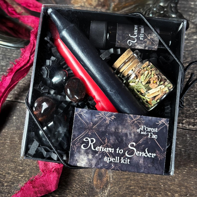 May include: A black box with a red candle, a small bottle of oil, a jar of herbs, and three black stones. The box has a label that says "Return to Sender spell kit" and "Forest and Fae".