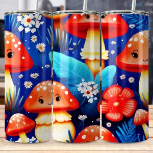 Puede incluir: Un vaso de acero inoxidable con un diseño caprichoso de setas. El vaso presenta un fondo azul vibrante con setas de dibujos animados en rojo, naranja y blanco, junto con flores blancas y hojas azules. El diseño envuelve todo el vaso.