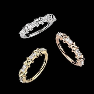 May include: Three diamond rings in different metal finishes: silver, gold, and rose gold. Each ring features a delicate, interwoven design with small, sparkling diamonds.