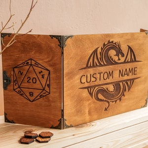 Może przedstawiać: Drewniana, trzyczęściowa plansza do gry z motywem smoka i tekstem "CUSTOM NAME". Lewy panel przedstawia dwudziestościenną kostkę.