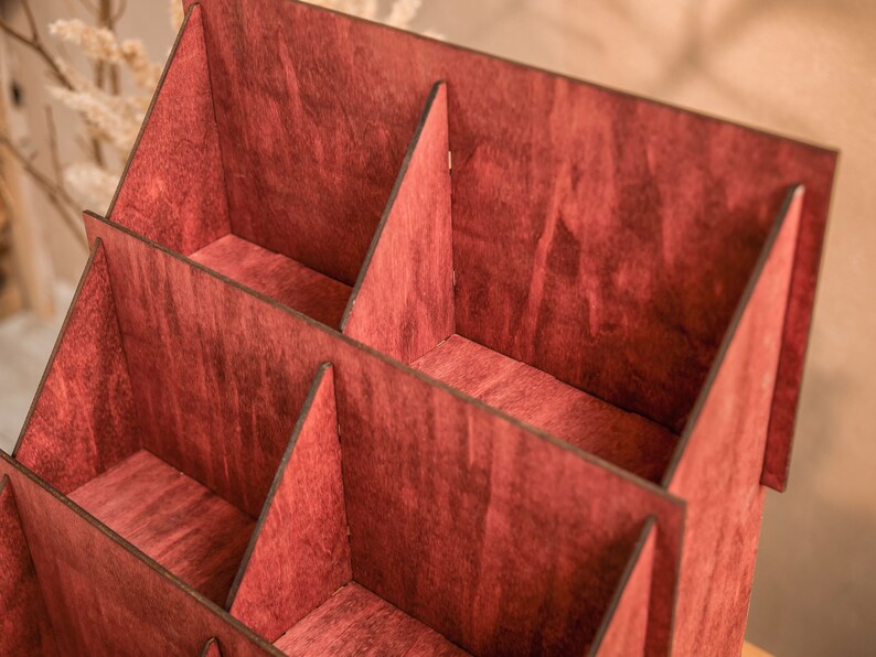 K&ouml;nnte beinhalten: Ein Holz-Pr&auml;sentationsst&auml;nder mit mehreren F&auml;chern, in einem tiefen Burgunderrot lackiert. Der St&auml;nder ist aus Sperrholz gefertigt und hat ein rustikales, handgemachtes Aussehen.