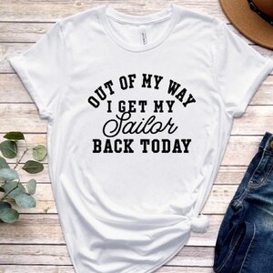 May include: White t-shirt with black text that reads "Out of my way I get my sailor back today".