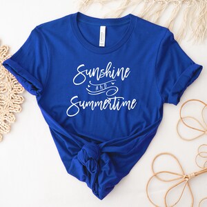 May include: A royal blue t-shirt with white text that reads "Sunshine and Summertime".