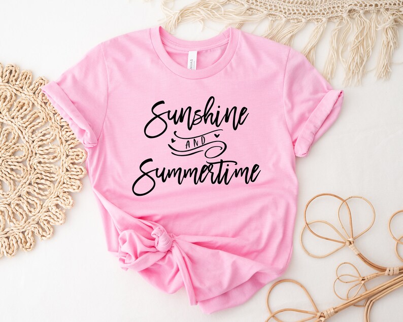 May include: Pink t-shirt with the text "Sunshine and Summertime" in black script font.