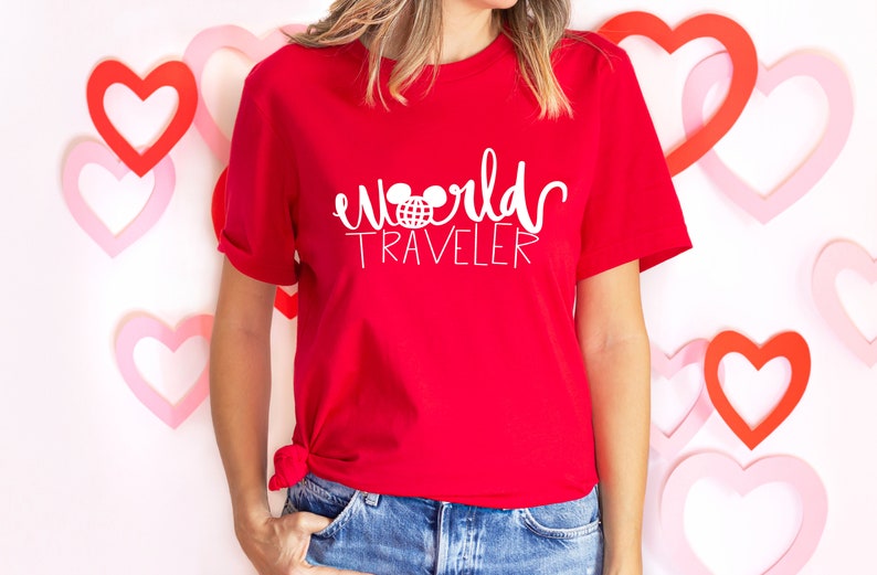 May include: Red t-shirt with white text that says "world traveler" and a white Mickey Mouse head with a globe inside the ears.