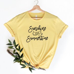 May include: A yellow t-shirt with the text "Sunshine and Summertime" in black script.