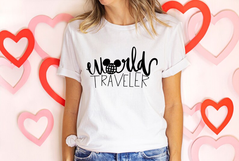 May include: White t-shirt with black text that reads "world traveler" with a Mickey Mouse head and globe graphic.