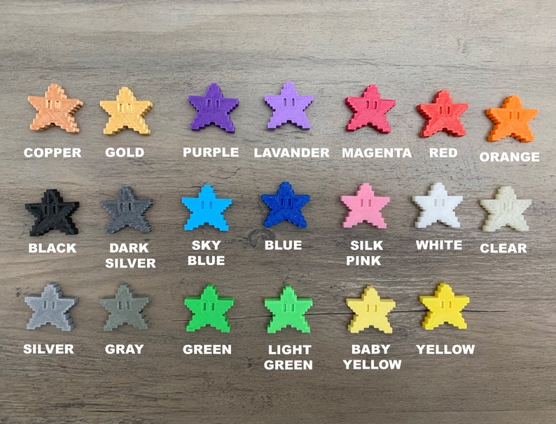 May include: A collection of 15 star-shaped buttons in various colours, including copper, gold, purple, lavender, magenta, red, orange, black, dark silver, sky blue, blue, silk pink, white, clear, silver, grey, green, light green, baby yellow, and yellow.