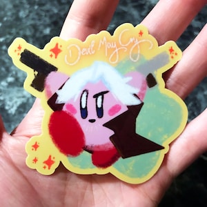 May include: A pink and red cartoon character with white hair holding a gun and a sword. The character is surrounded by yellow stars and the text "Devil May Cry" is written in white cursive.