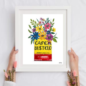 May include: A framed art print featuring a vibrant floral arrangement atop a yellow and red Cafe Bustelo coffee can. The artwork includes the brand name and coffee details, with a weight of 10.10 ounces.